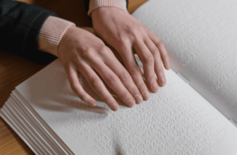 A close-up image of a Braille Quran book with raised dots on its pages.